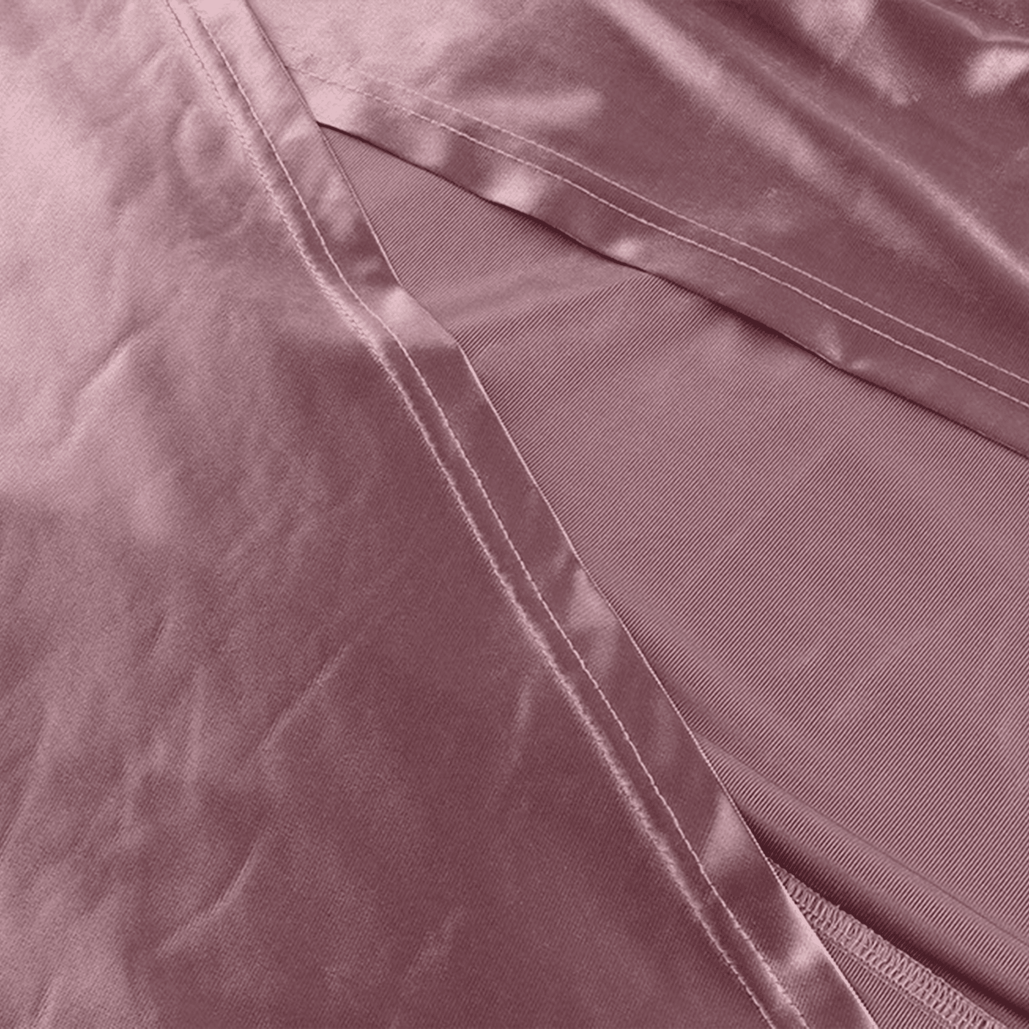 Close-up of a pink satin pillowcase with a subtle sheen.