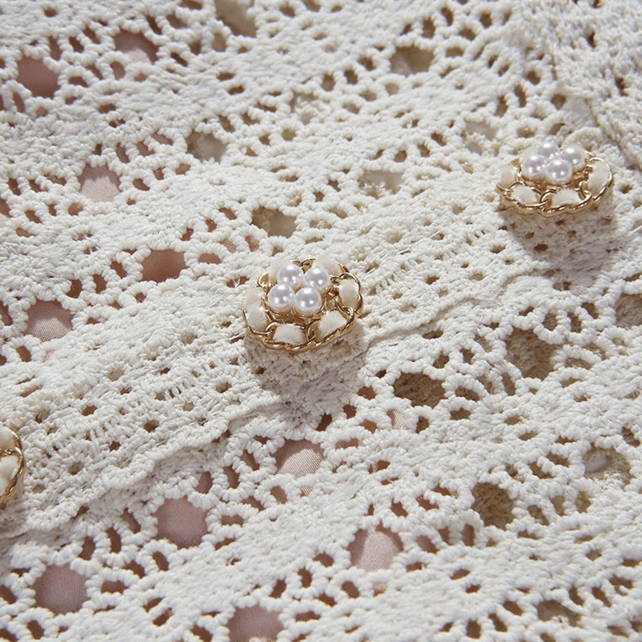 Pearl earrings on a lace fabric background