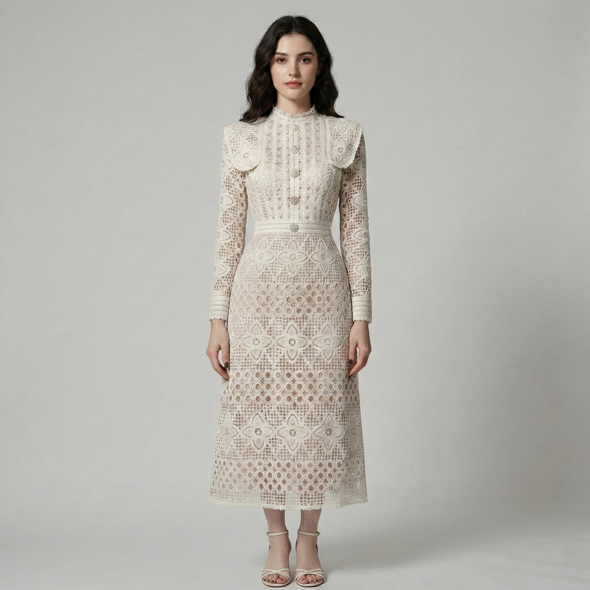 Woman wearing a long-sleeve lace dress against a plain background