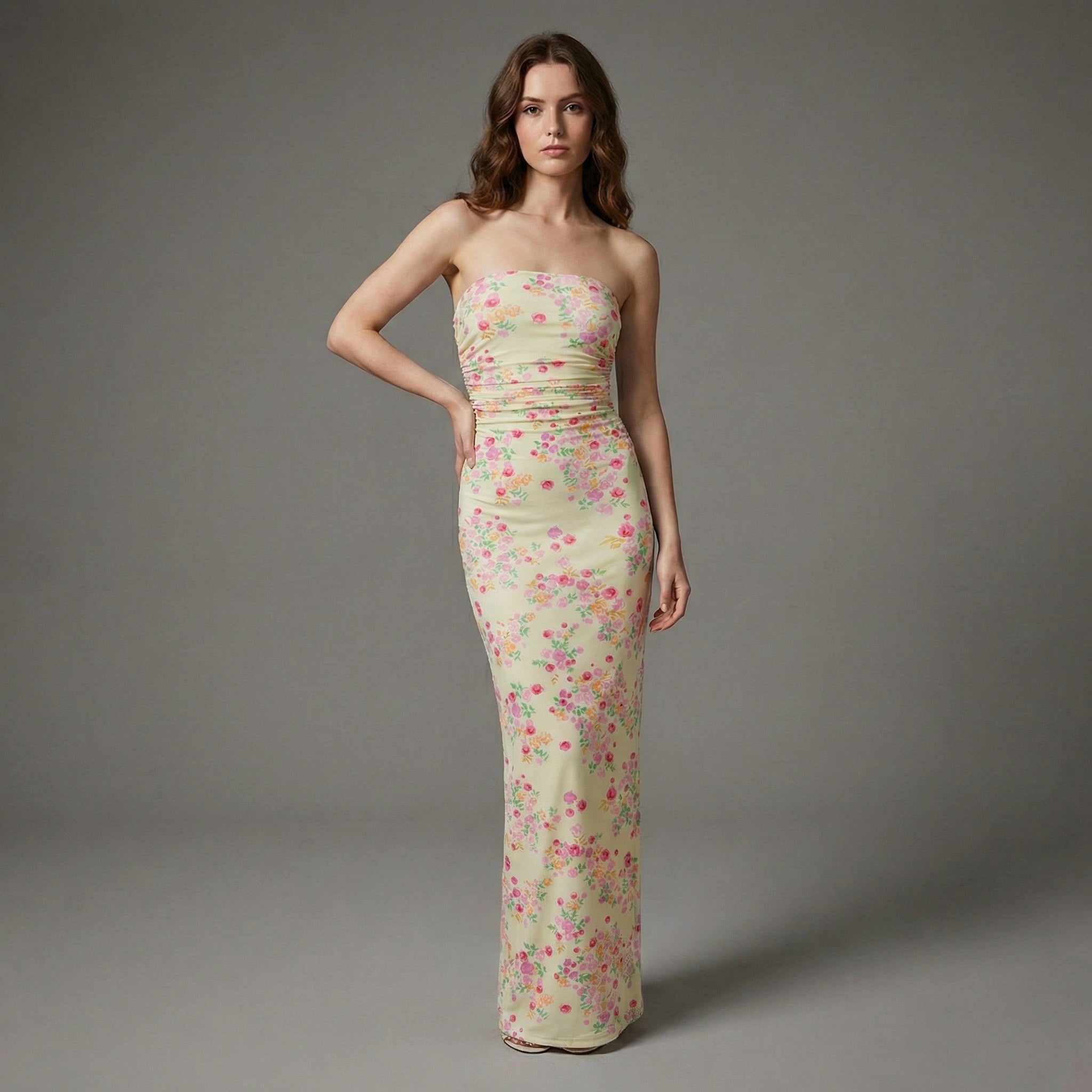 Woman wearing a strapless floral gown against a gray background