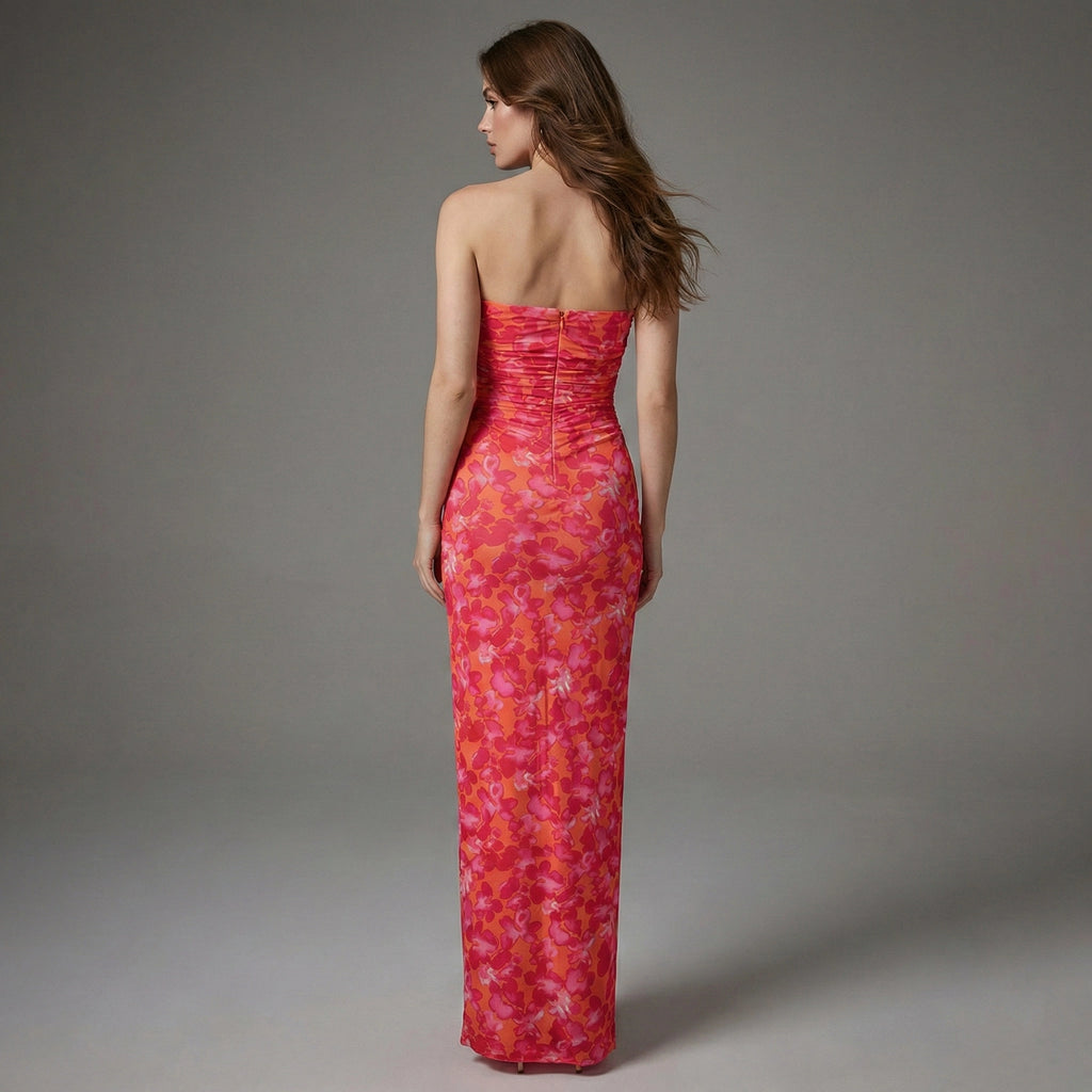 Woman wearing a strapless red floral dress against a gray background