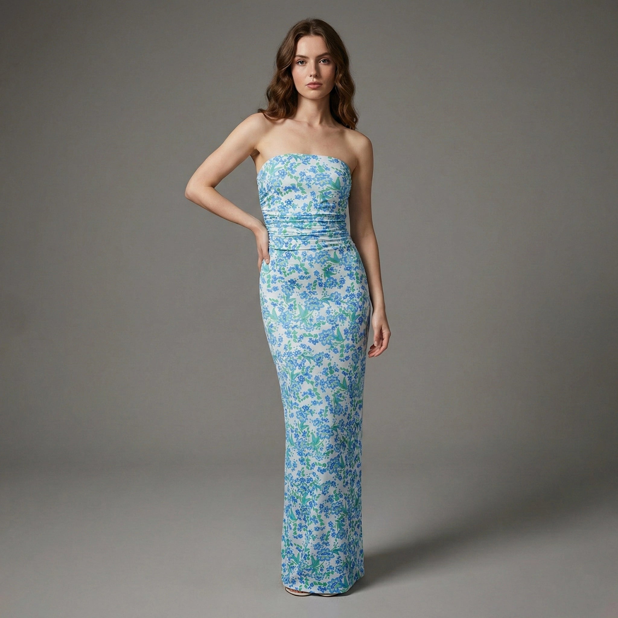 Woman wearing a strapless floral gown against a gray background