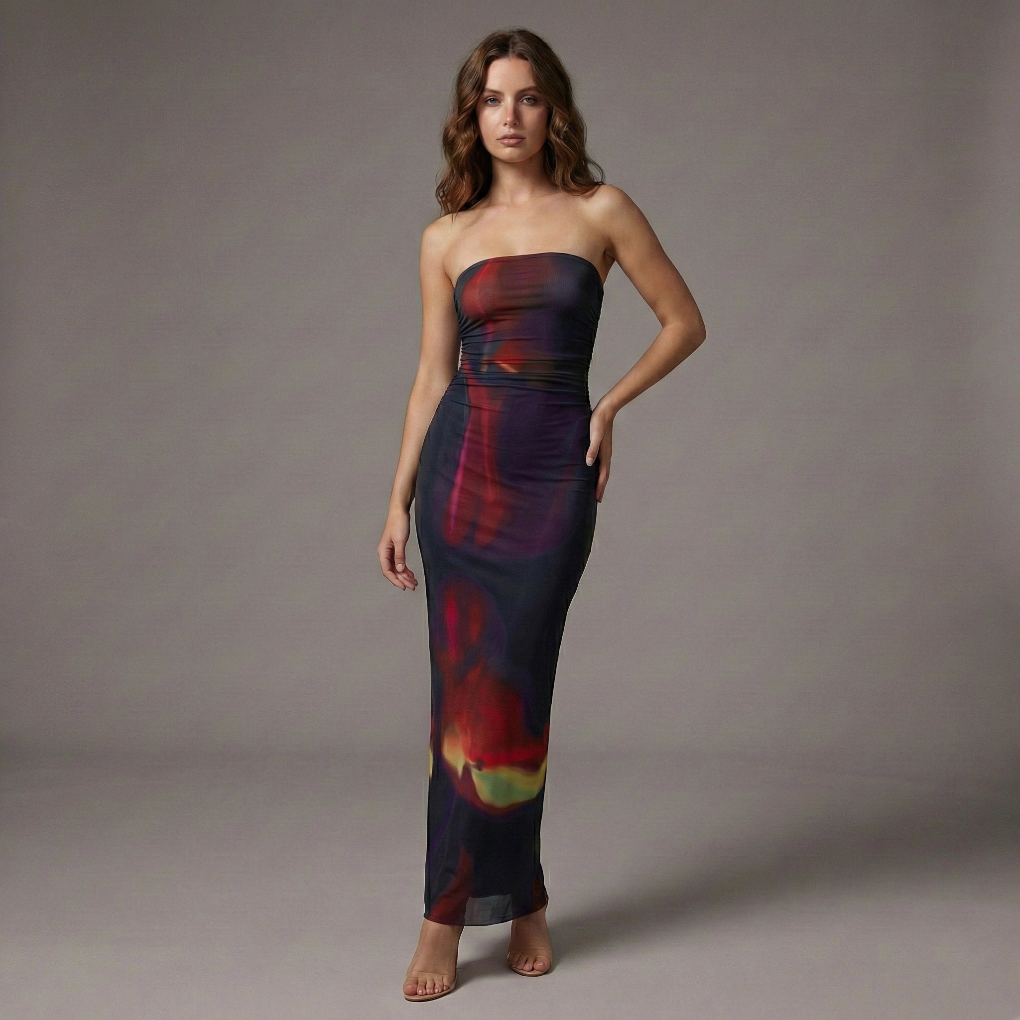 Woman wearing a strapless, multicolored dress against a gray background