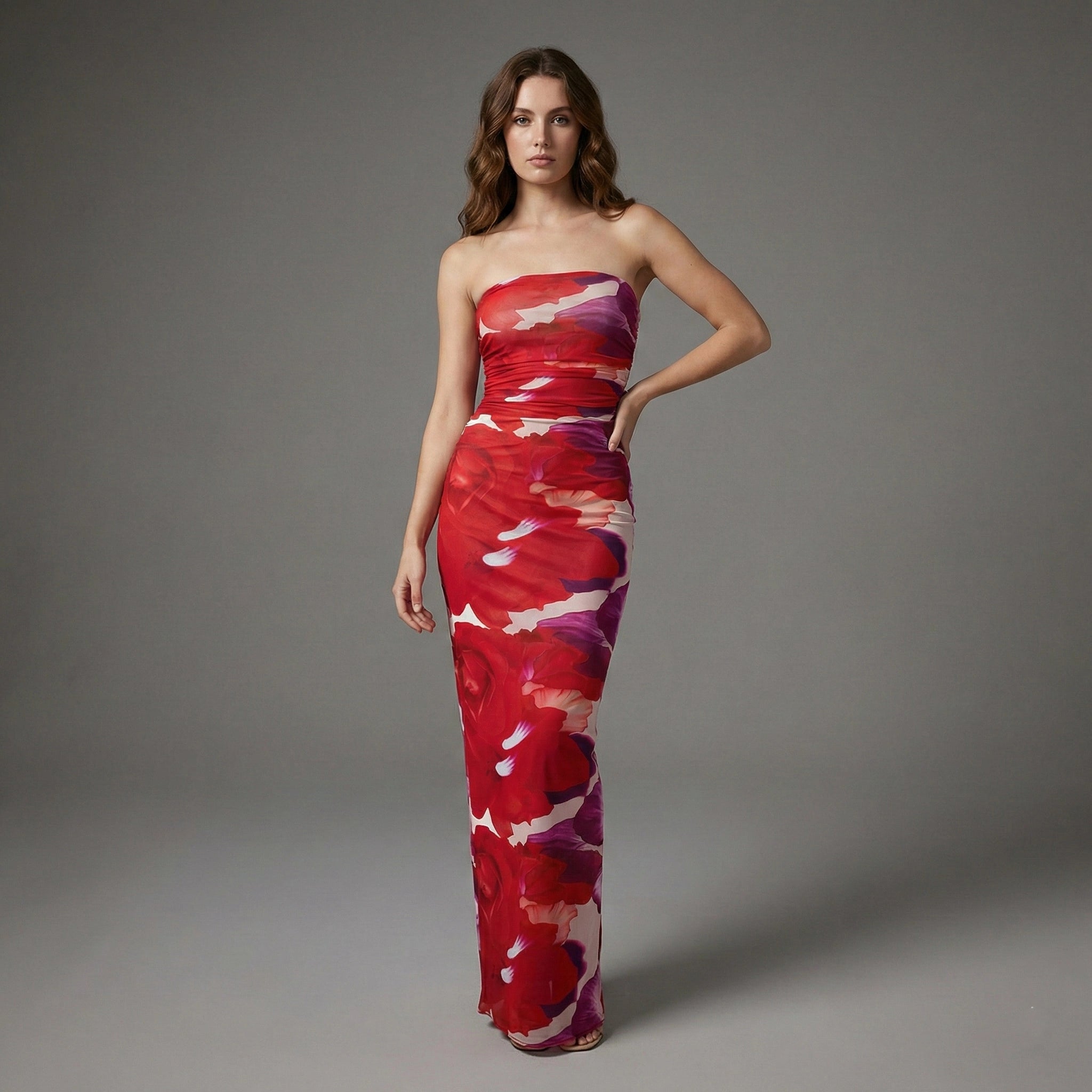 Woman wearing a strapless red and purple patterned dress on a gray background