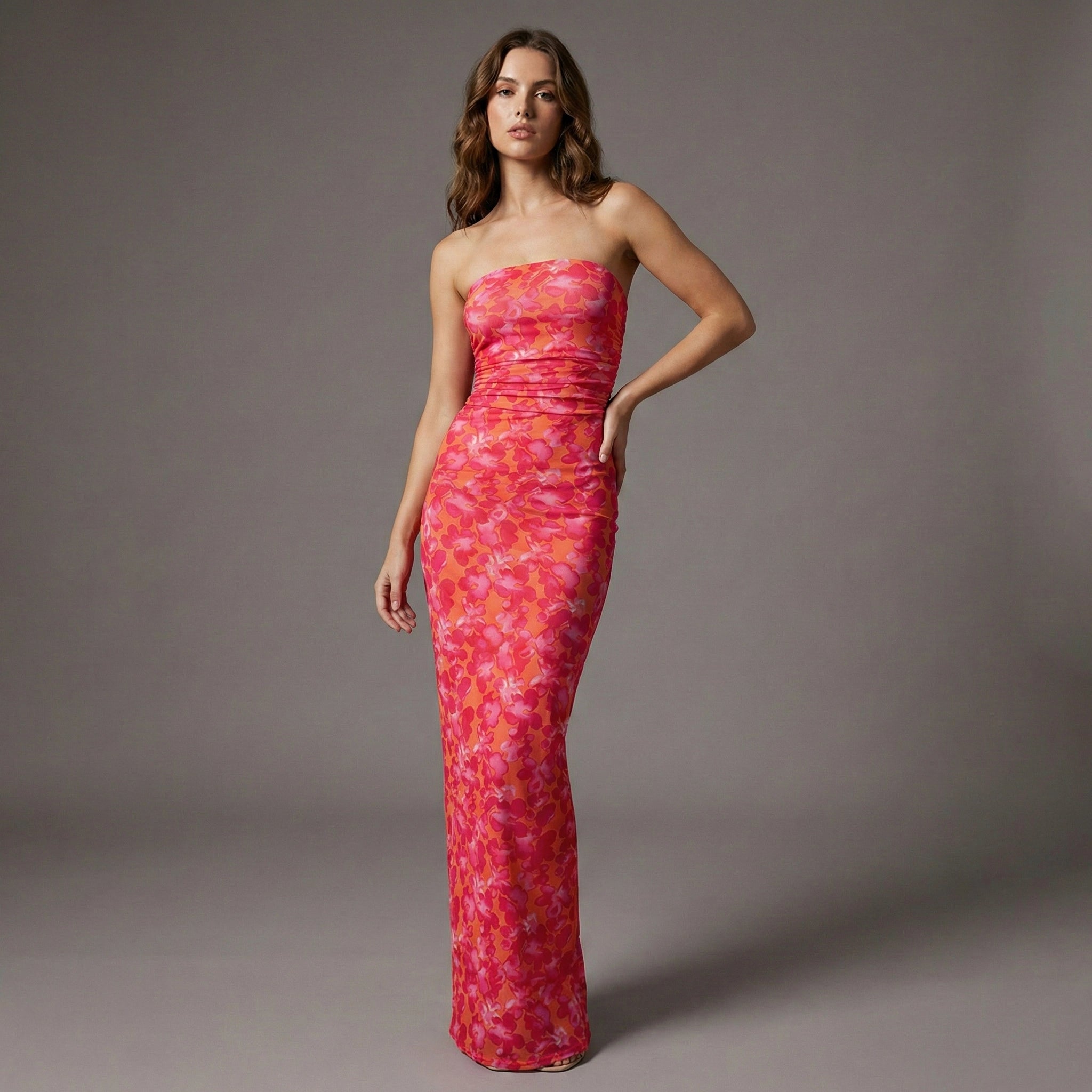 Woman wearing a strapless pink floral dress against a gray background