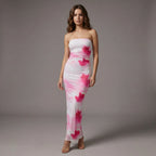 Woman wearing a strapless dress with pink abstract patterns on a gray background