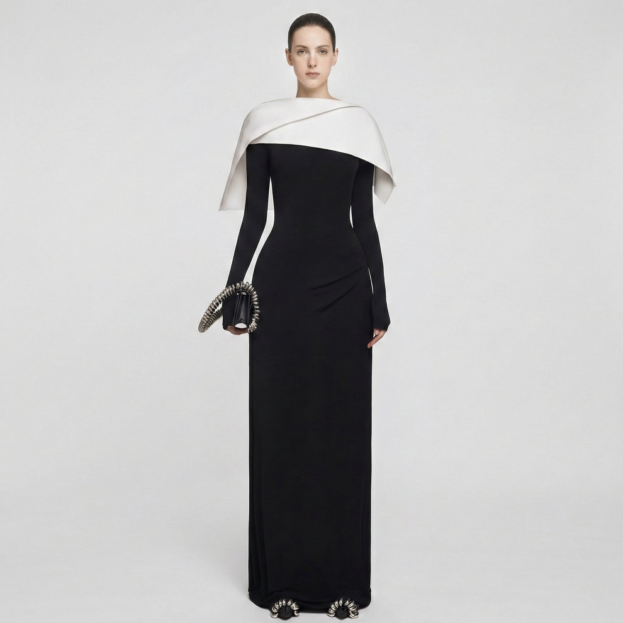 Woman wearing a black and white evening gown on a light gray background