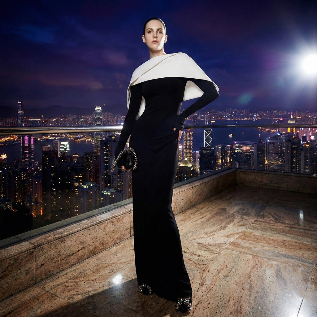 Woman in a black and white dress standing on a rooftop with a cityscape in the background
