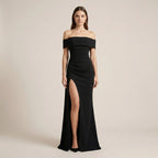 Black off-shoulder gown with a high slit on a beige background