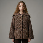 Woman wearing a brown patterned coat against a gray background
