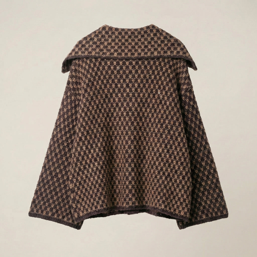 Houndstooth patterned cape on a beige background