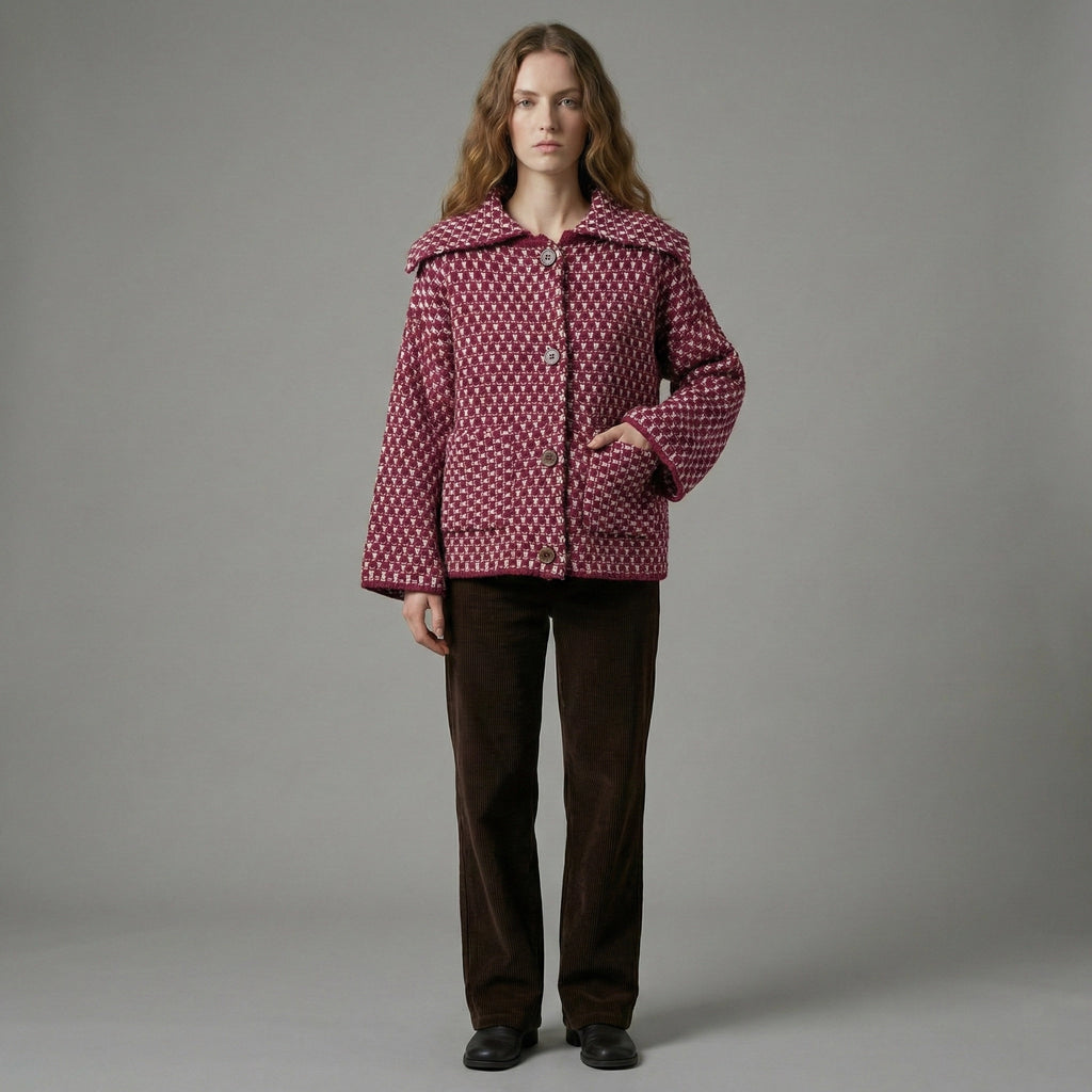 Person wearing a patterned jacket and brown pants on a gray background