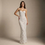 Woman wearing a white lace dress against a beige background