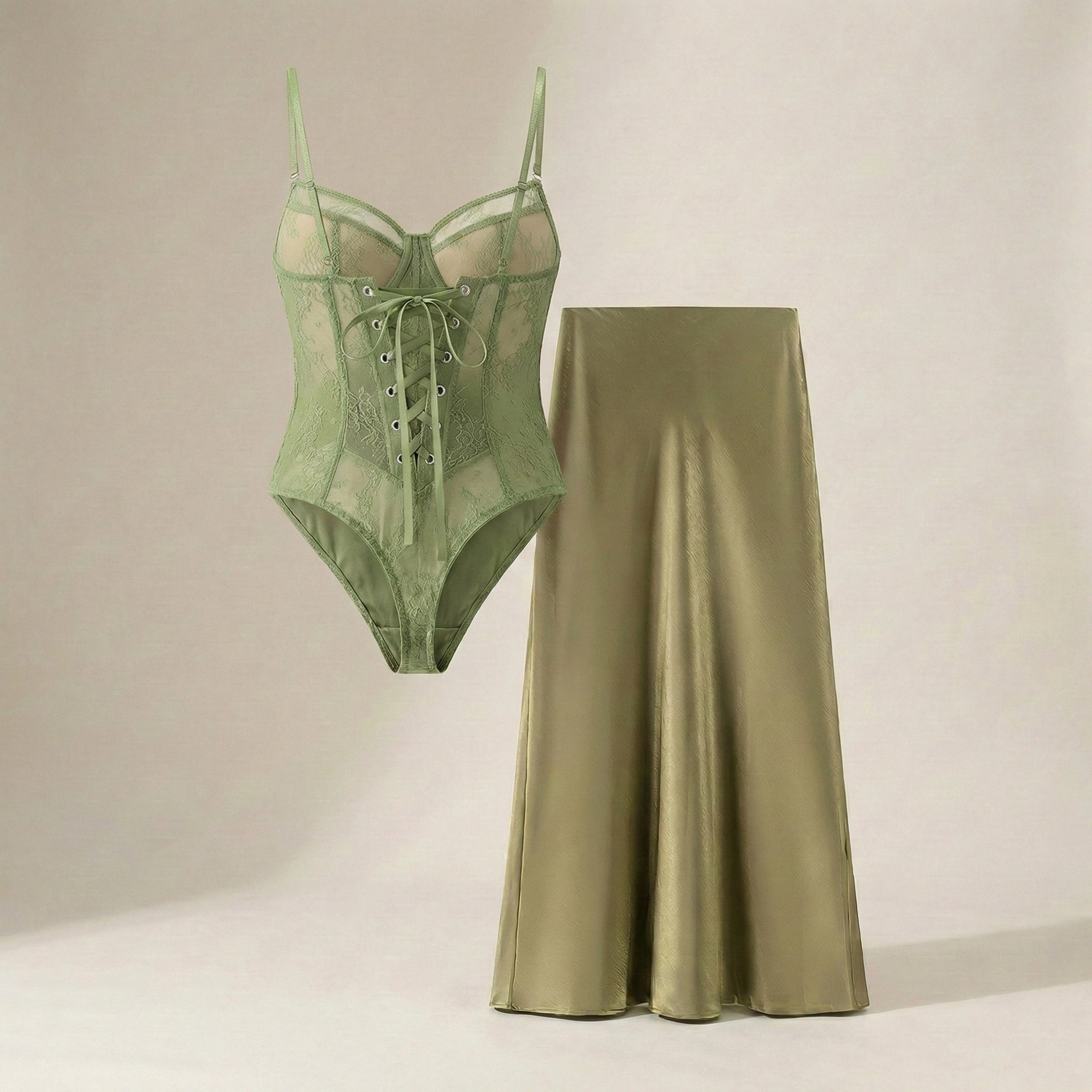 Green lace-up bodysuit and satin skirt on a neutral background