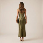 Woman wearing a green dress with a beige background