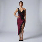 Woman wearing a burgundy dress with black lace details on a gray background