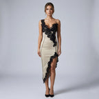 Woman wearing a beige evening gown with black lace details on a gray background