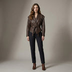 Woman wearing a brown leather jacket and black pants against a neutral background