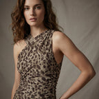 Woman wearing a leopard print dress against a neutral background