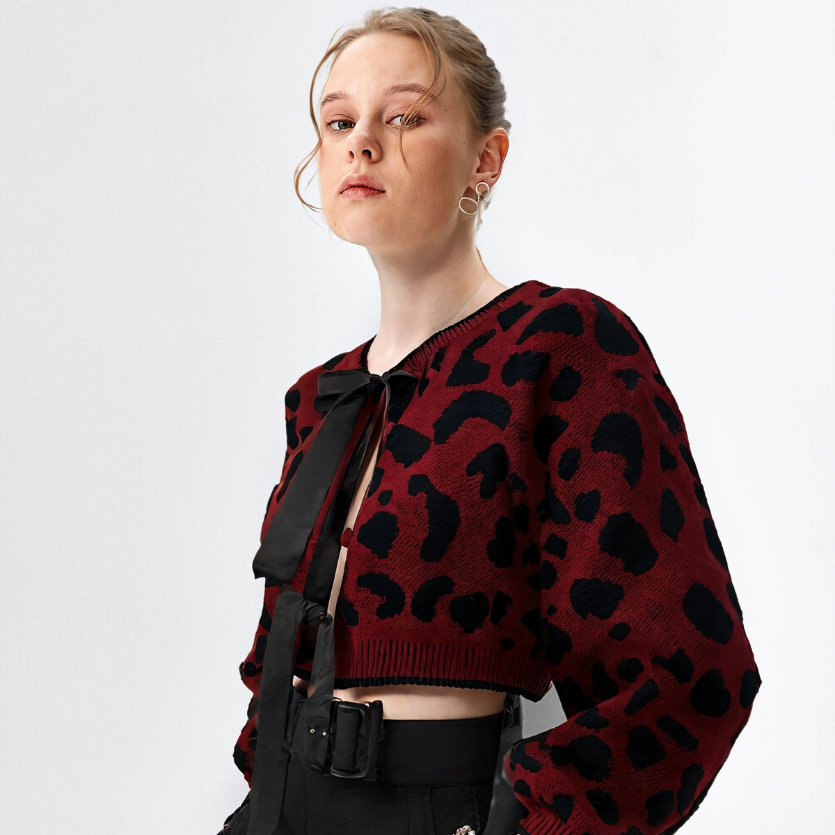 Person wearing a red and black patterned sweater with a plain background