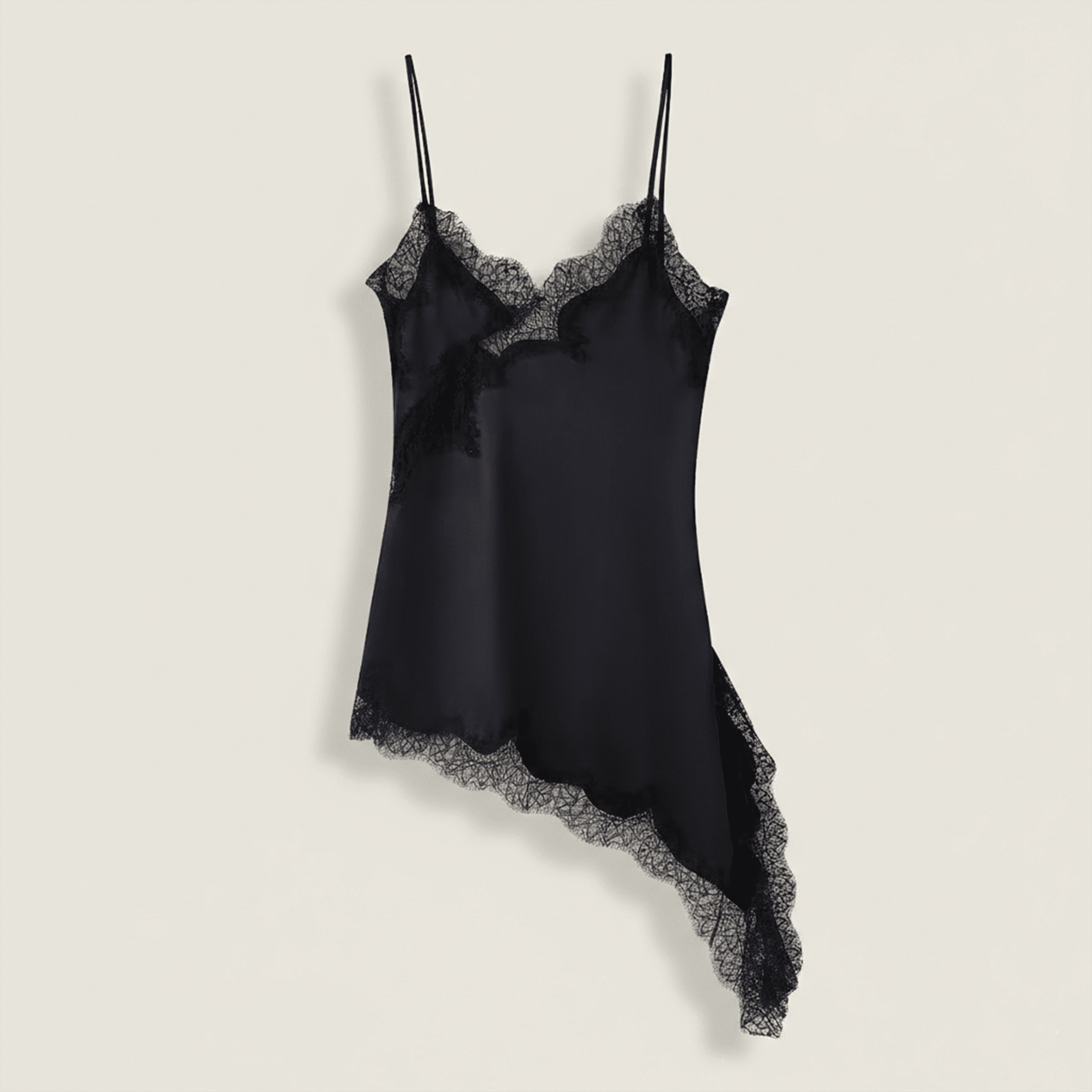 Black satin slip dress with lace trim on a light beige background