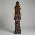 Woman wearing a leopard print dress against a gray background