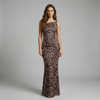 Woman wearing a leopard print one-shoulder dress on a gray background