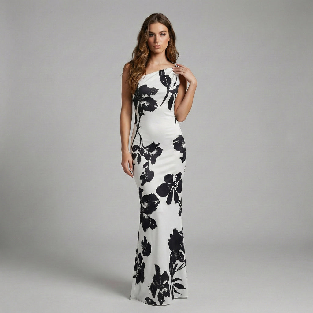 Woman wearing a white dress with black floral patterns on a gray background