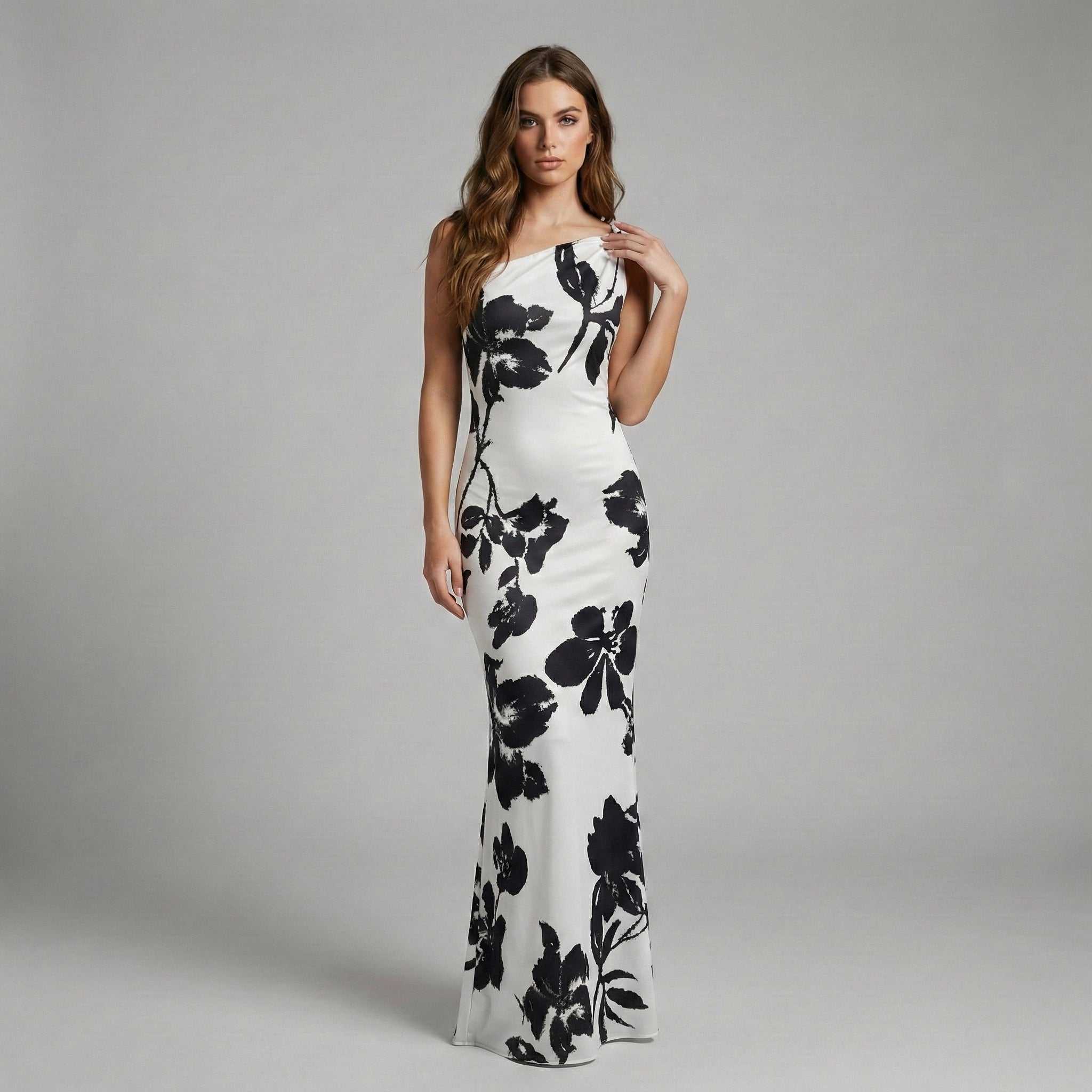 Woman wearing a white dress with black floral patterns on a gray background