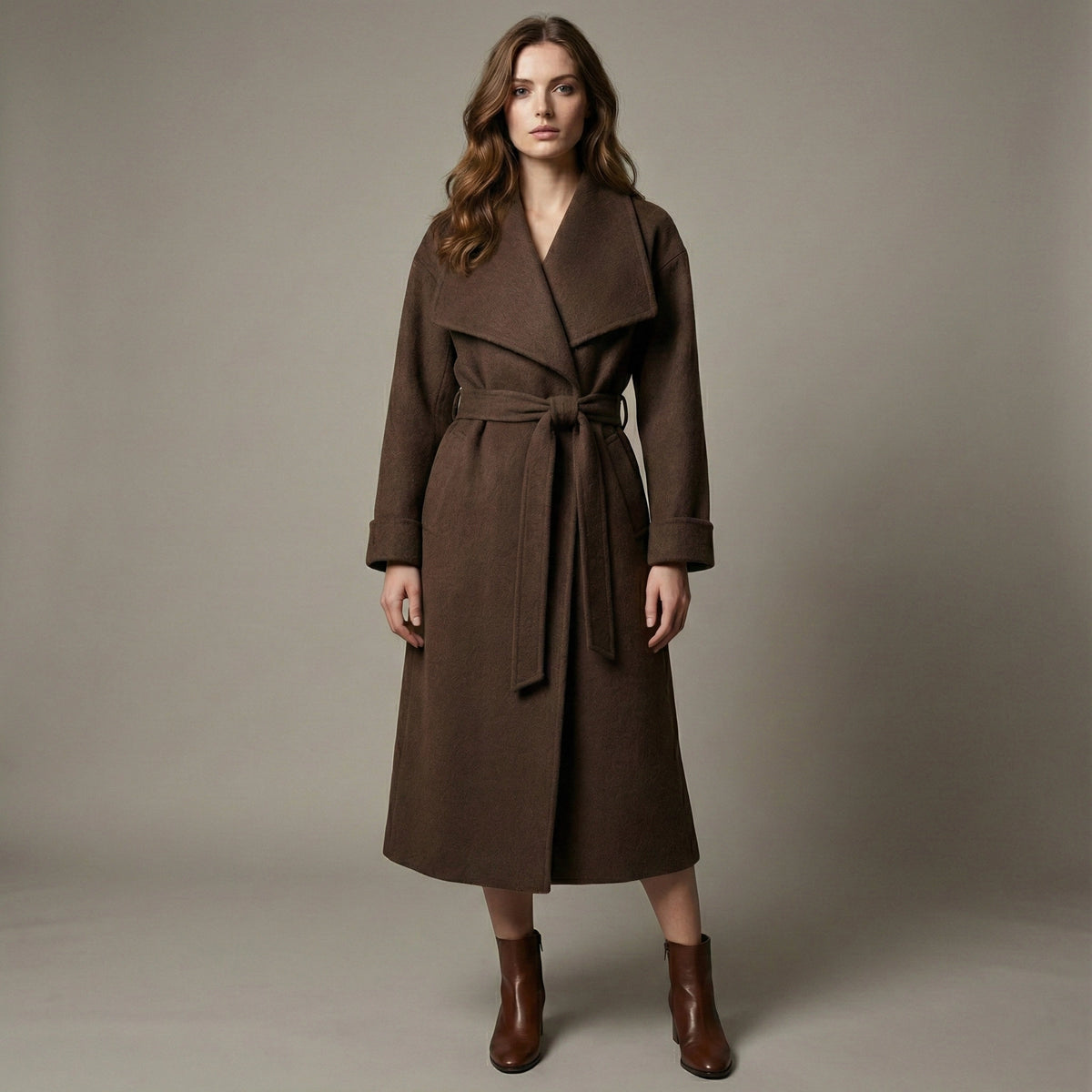 Woman wearing a brown coat against a plain background