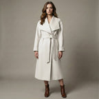Woman wearing a white coat with a belt against a neutral background