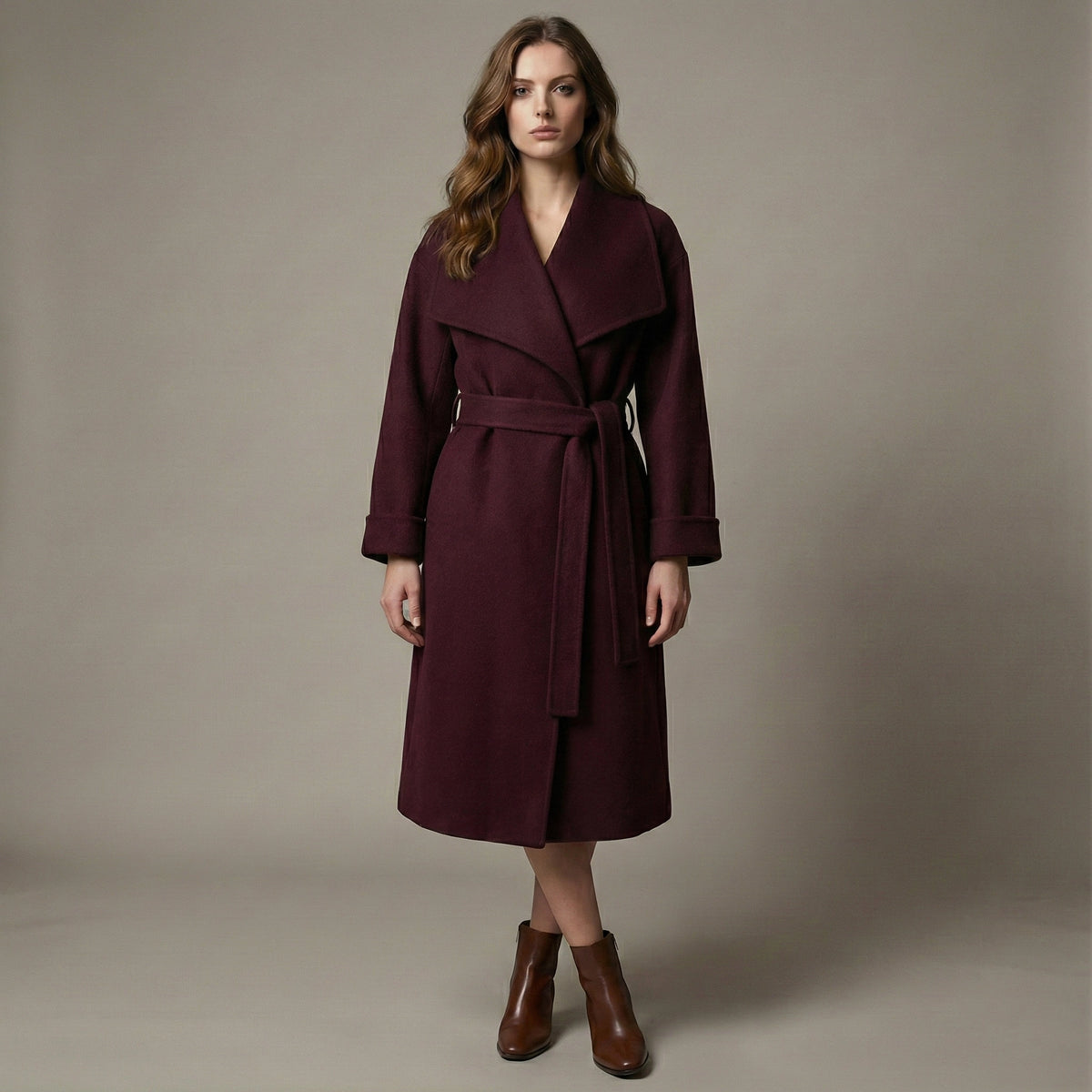 Woman wearing a burgundy coat against a neutral background