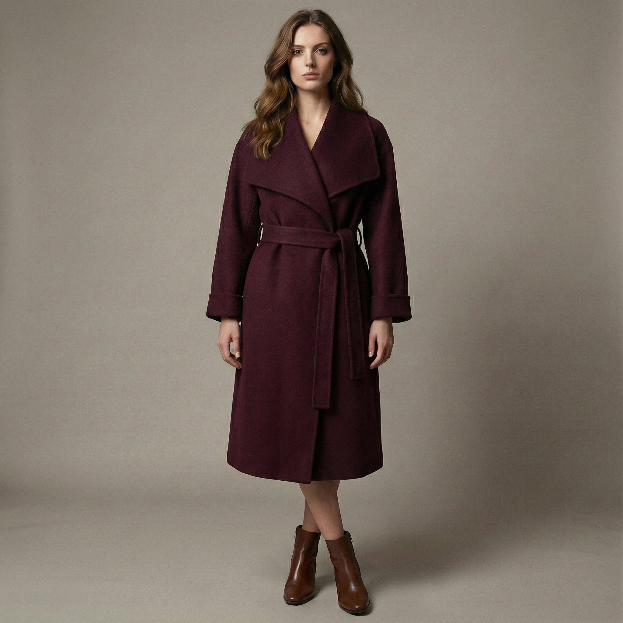 Woman wearing a burgundy coat against a neutral background
