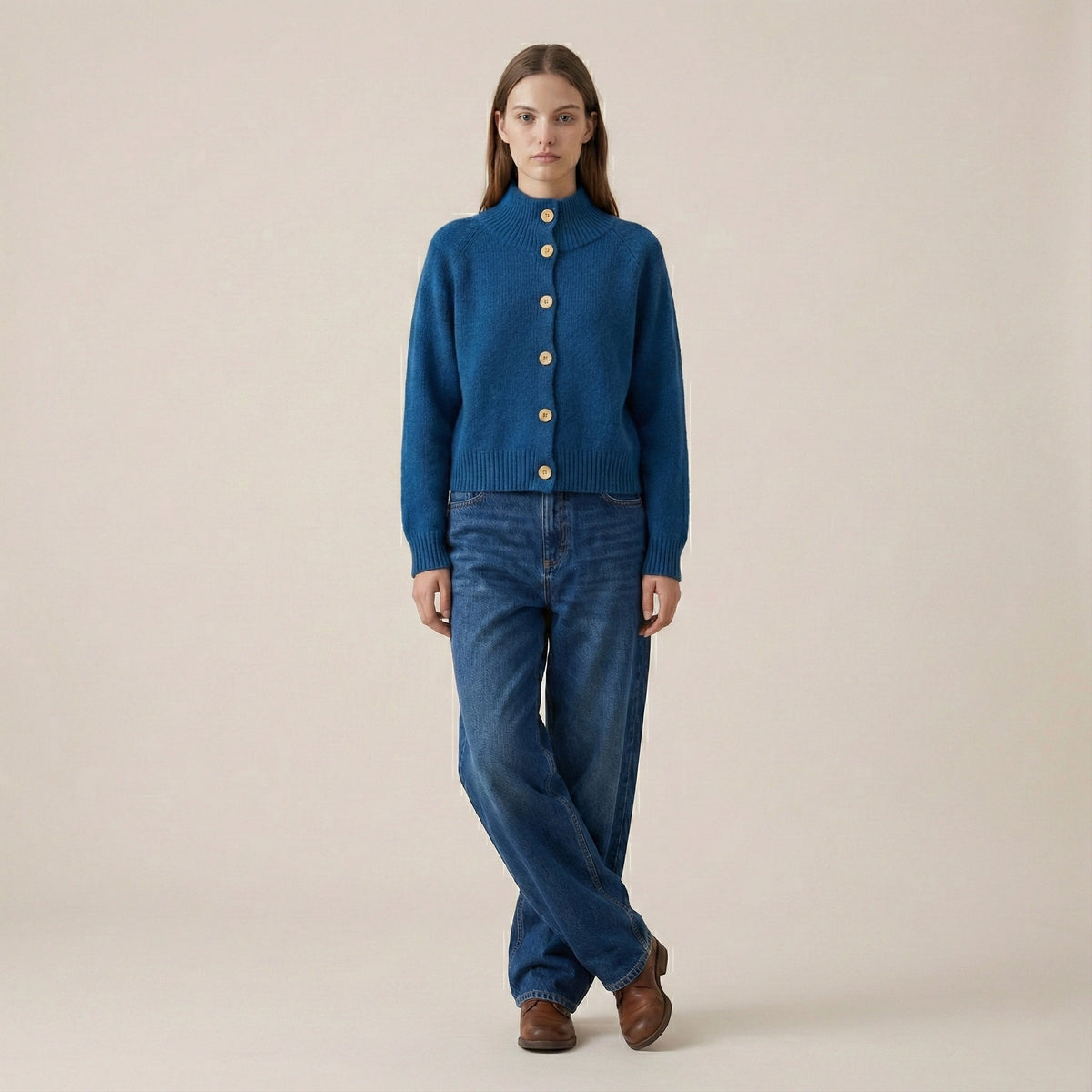 Woman wearing a blue jacket and jeans on a beige background