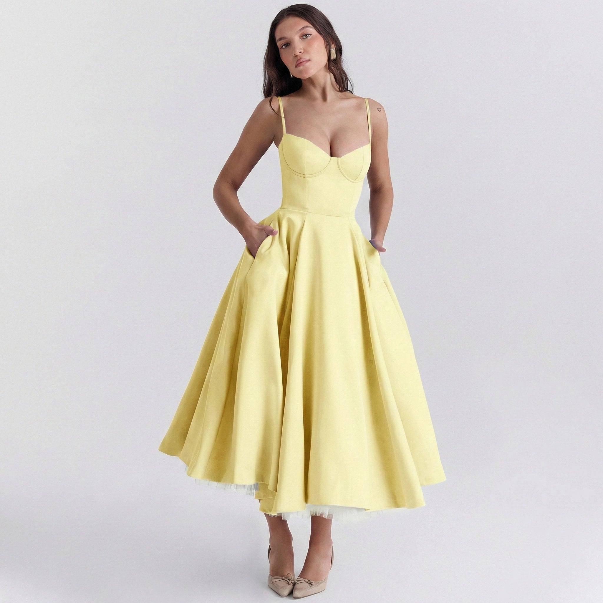 Woman wearing a yellow dress on a light gray background