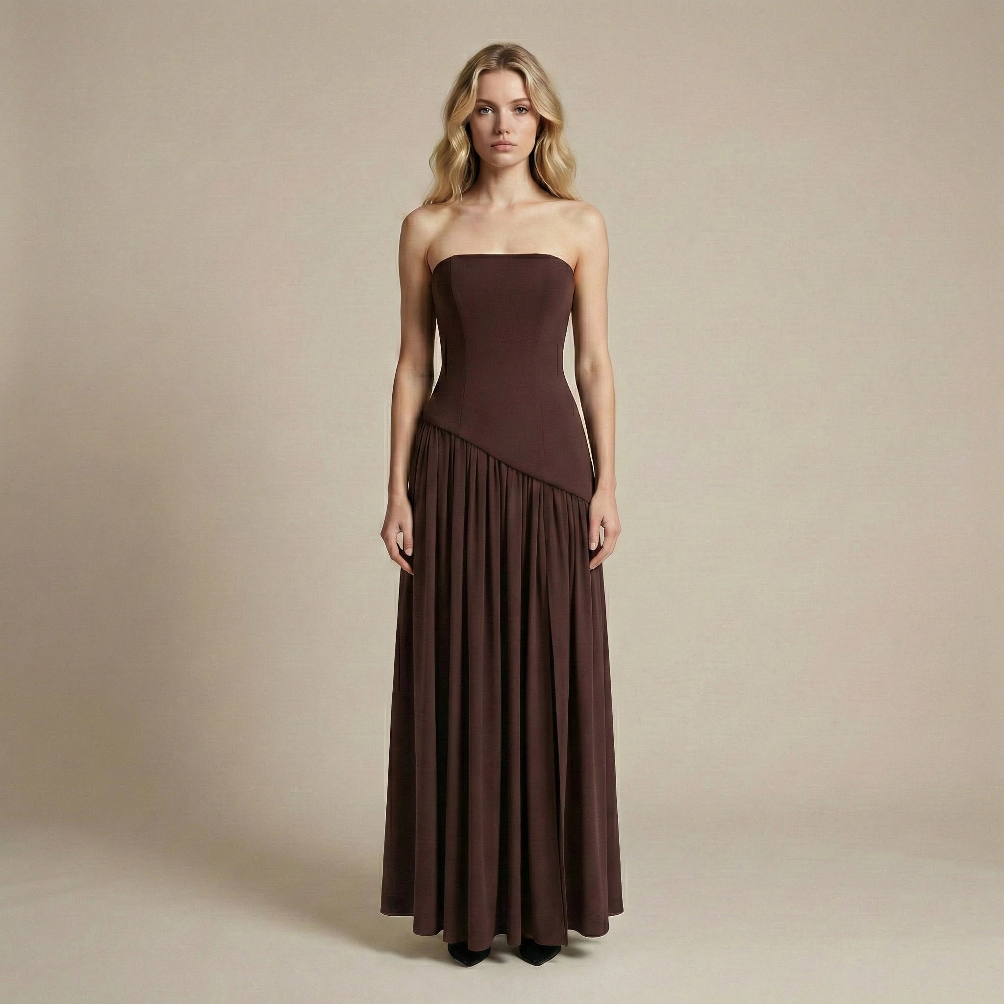 Woman wearing a strapless brown evening gown against a plain background