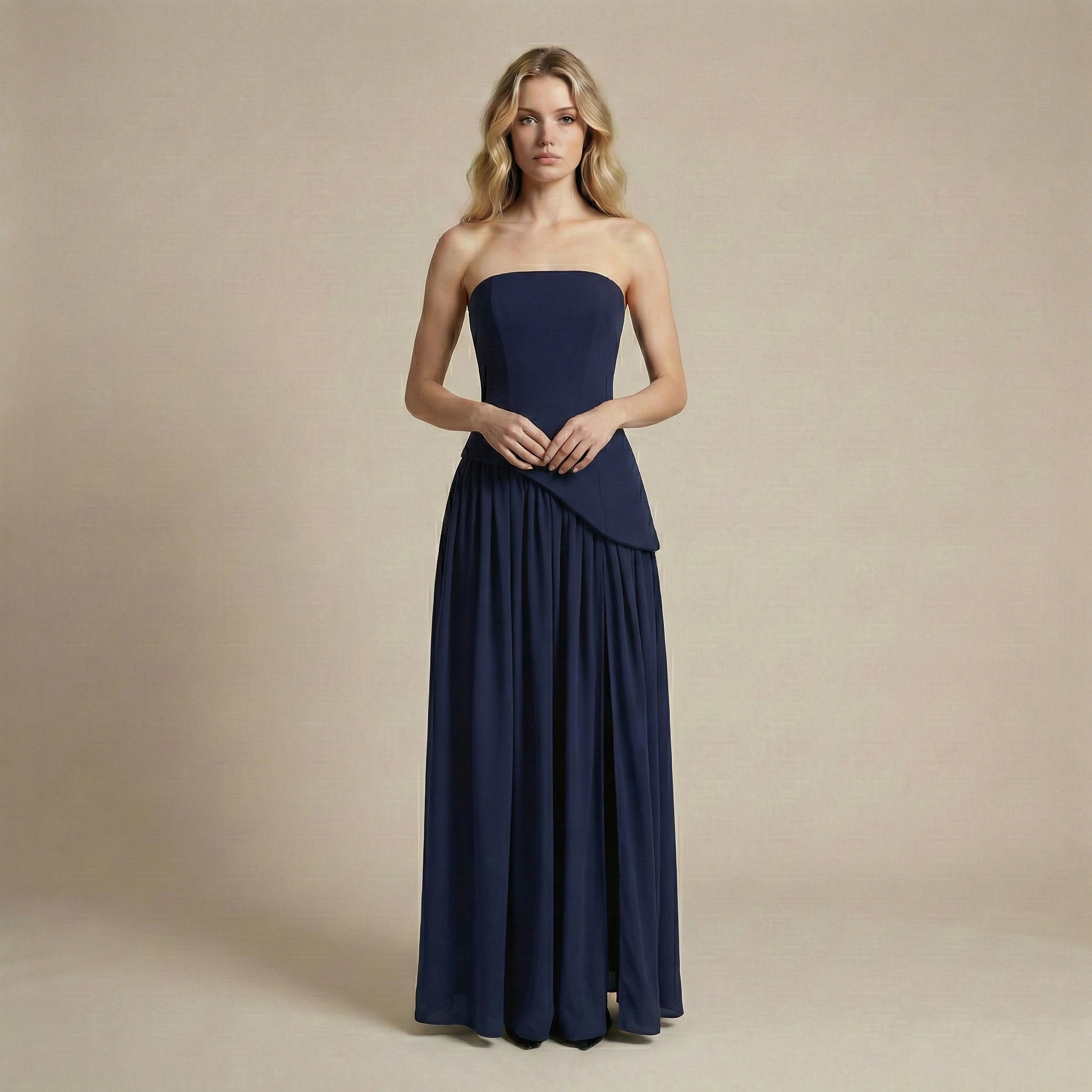 Woman wearing a strapless navy blue gown against a beige background