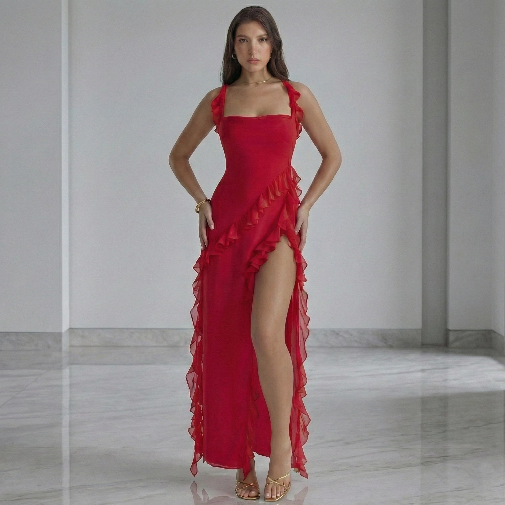 Woman wearing a red dress with ruffled details in a minimalistic setting