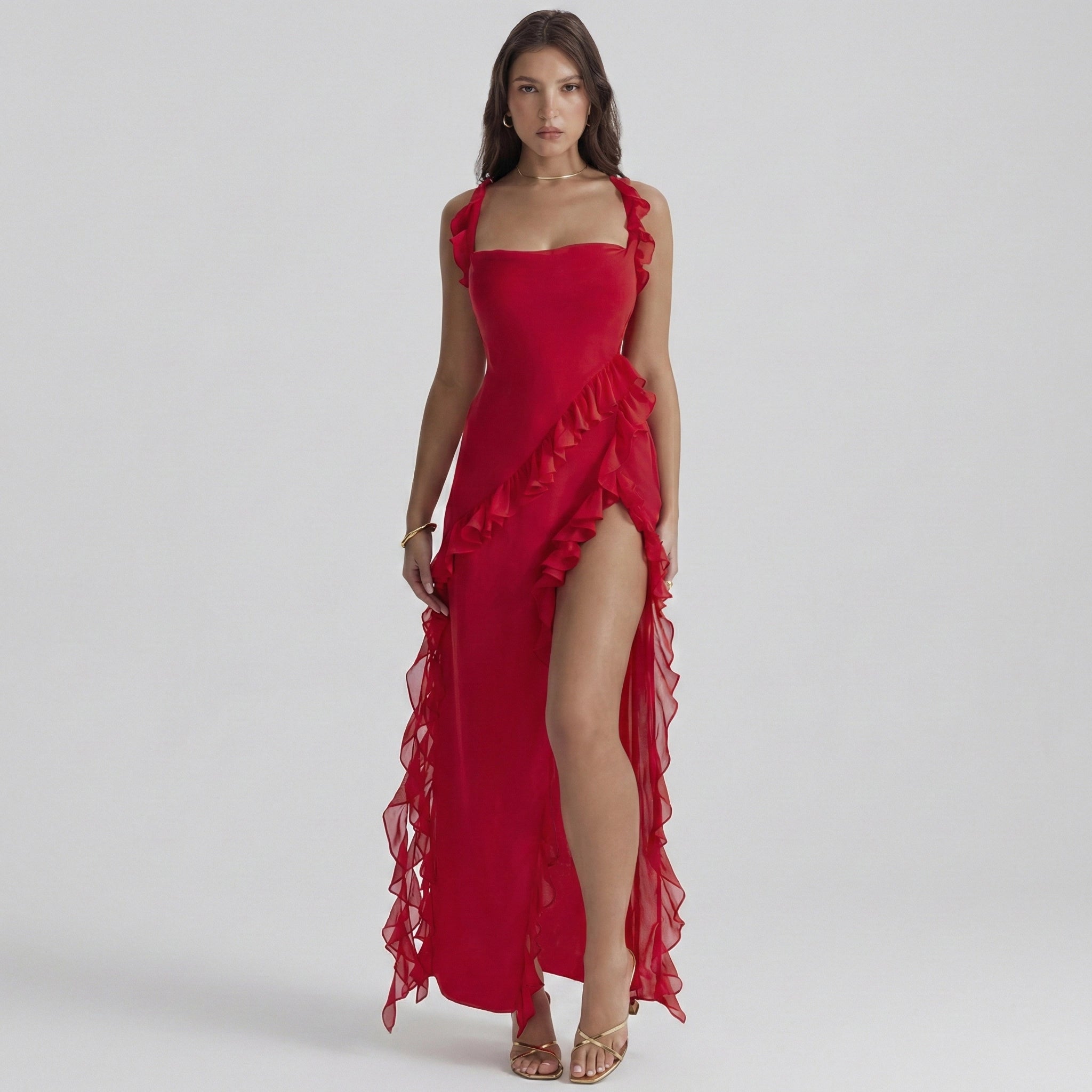 Woman wearing a red evening gown with ruffles on a gray background