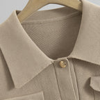 Close-up of a beige textured shirt with a button on a hanger