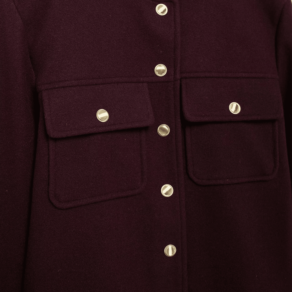 Close-up of a dark purple coat with gold buttons on a dark background