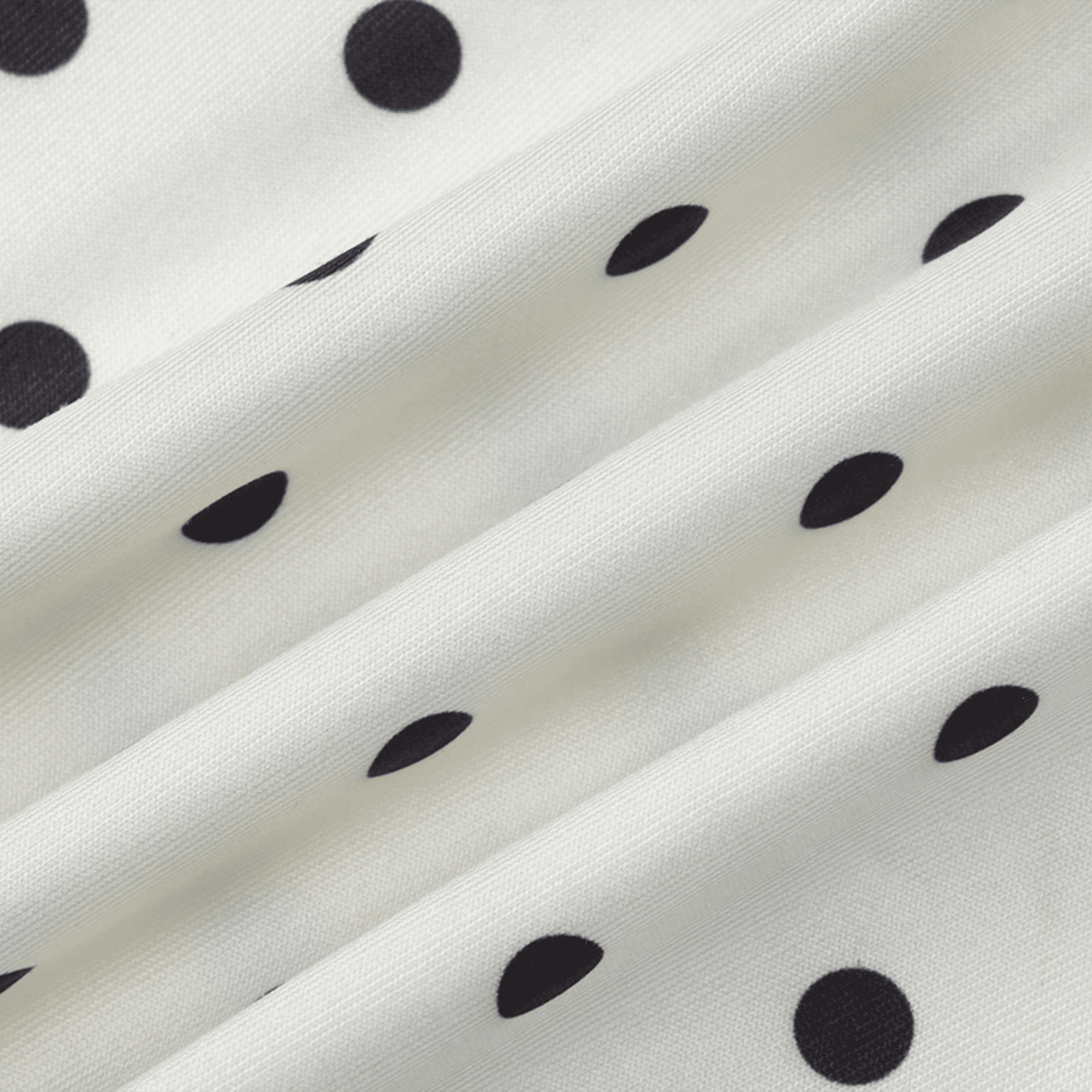 Close-up of white fabric with black polka dots