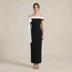 Woman wearing a black and white off-shoulder dress on a beige background