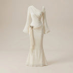 Elegant one-shoulder white dress with long sleeves on a beige background