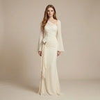 Woman wearing a long, elegant cream dress with a matching jacket against a beige background