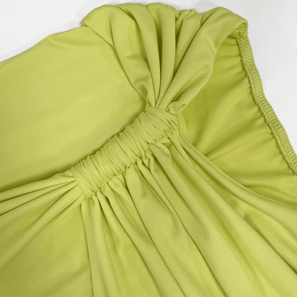 Close-up of a green dress with a bow detail on a white background