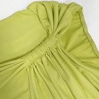Close-up of a green dress with a bow detail on a white background