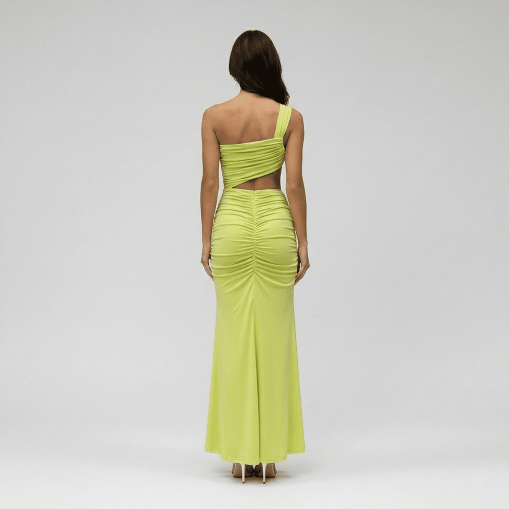 Woman wearing a bright green one-shoulder dress on a gray background