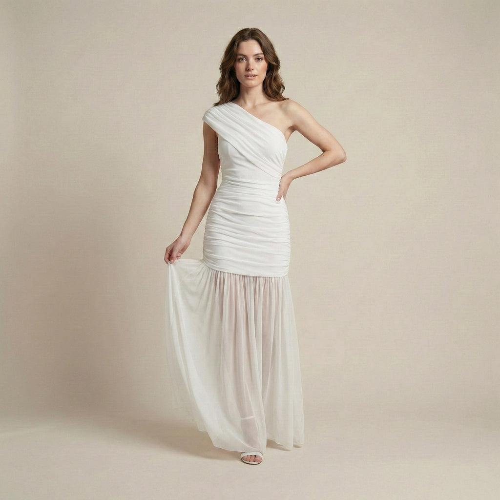 Woman wearing a white one-shoulder dress against a beige background