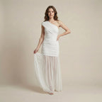 Woman wearing a white one-shoulder dress against a beige background